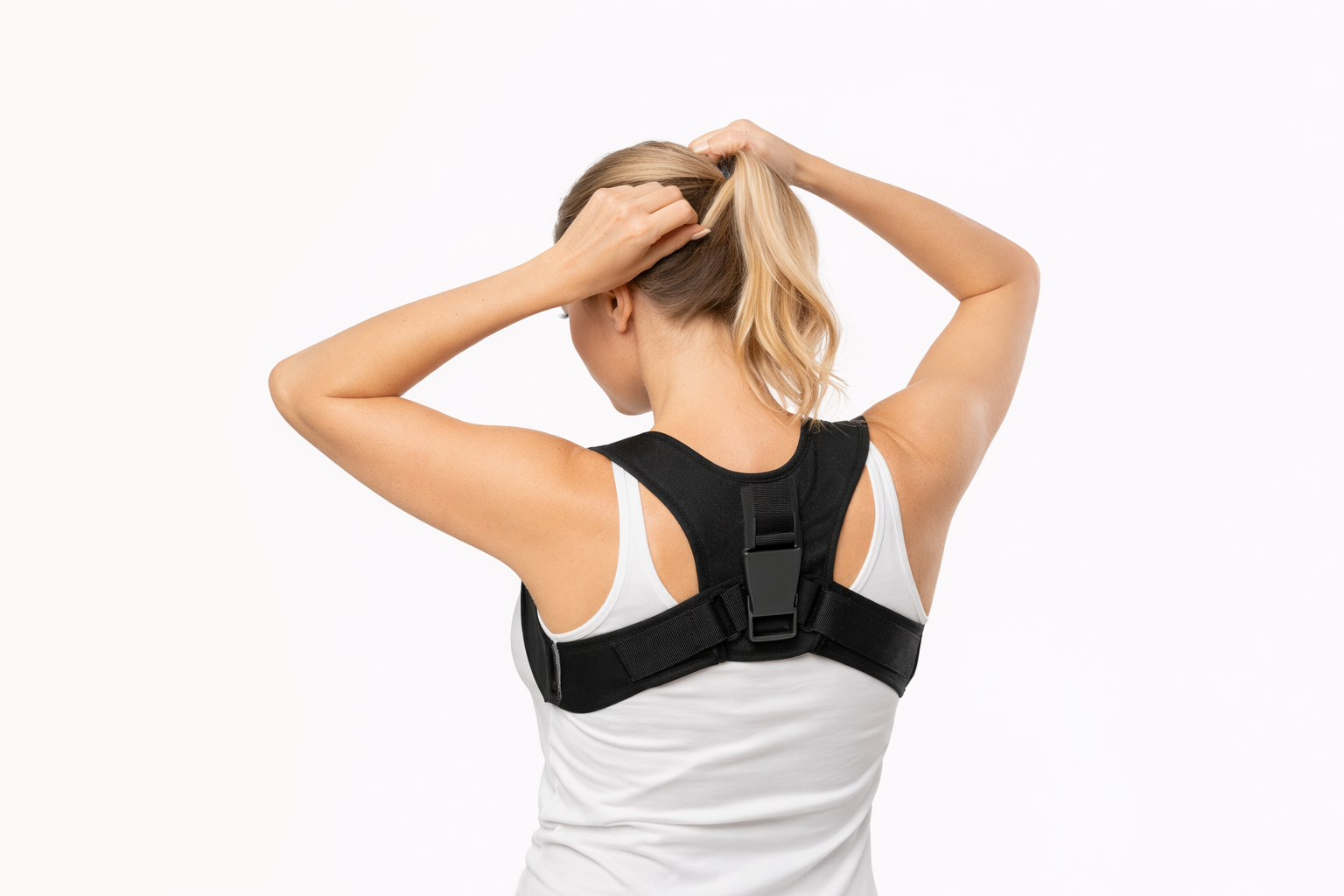 Woman wearing a black posture corrector on her back over a white tank top